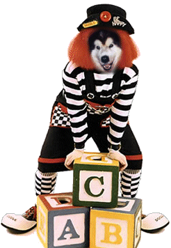 Harley the clown (orange hair, striped suit, sitting on a giant toy block)