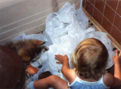 Penny helps Steph unroll a whole roll of toilet paper
